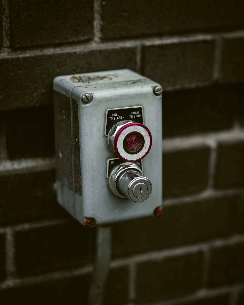 gray metal tool on brick wall