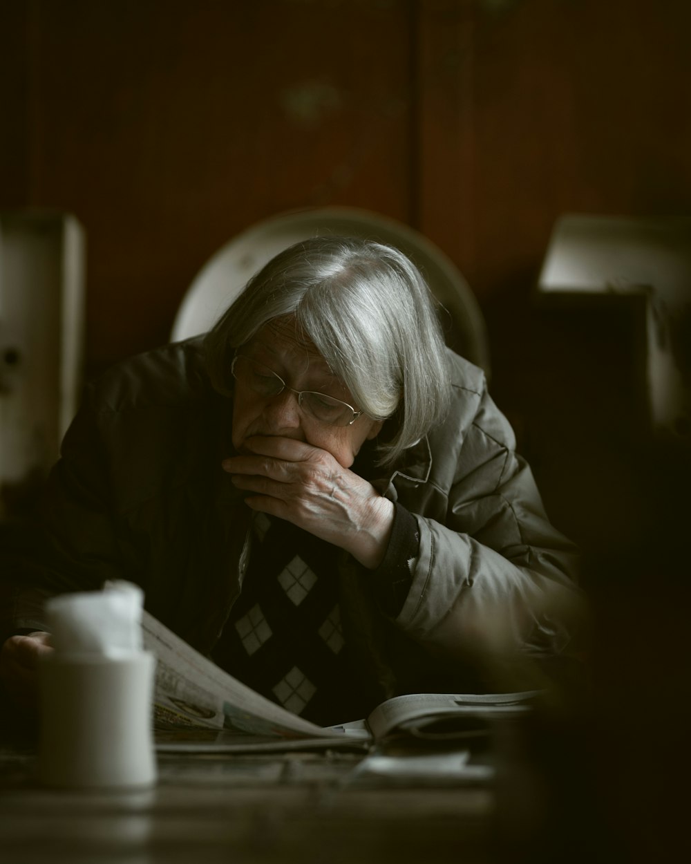 woman sitting at the table while reading