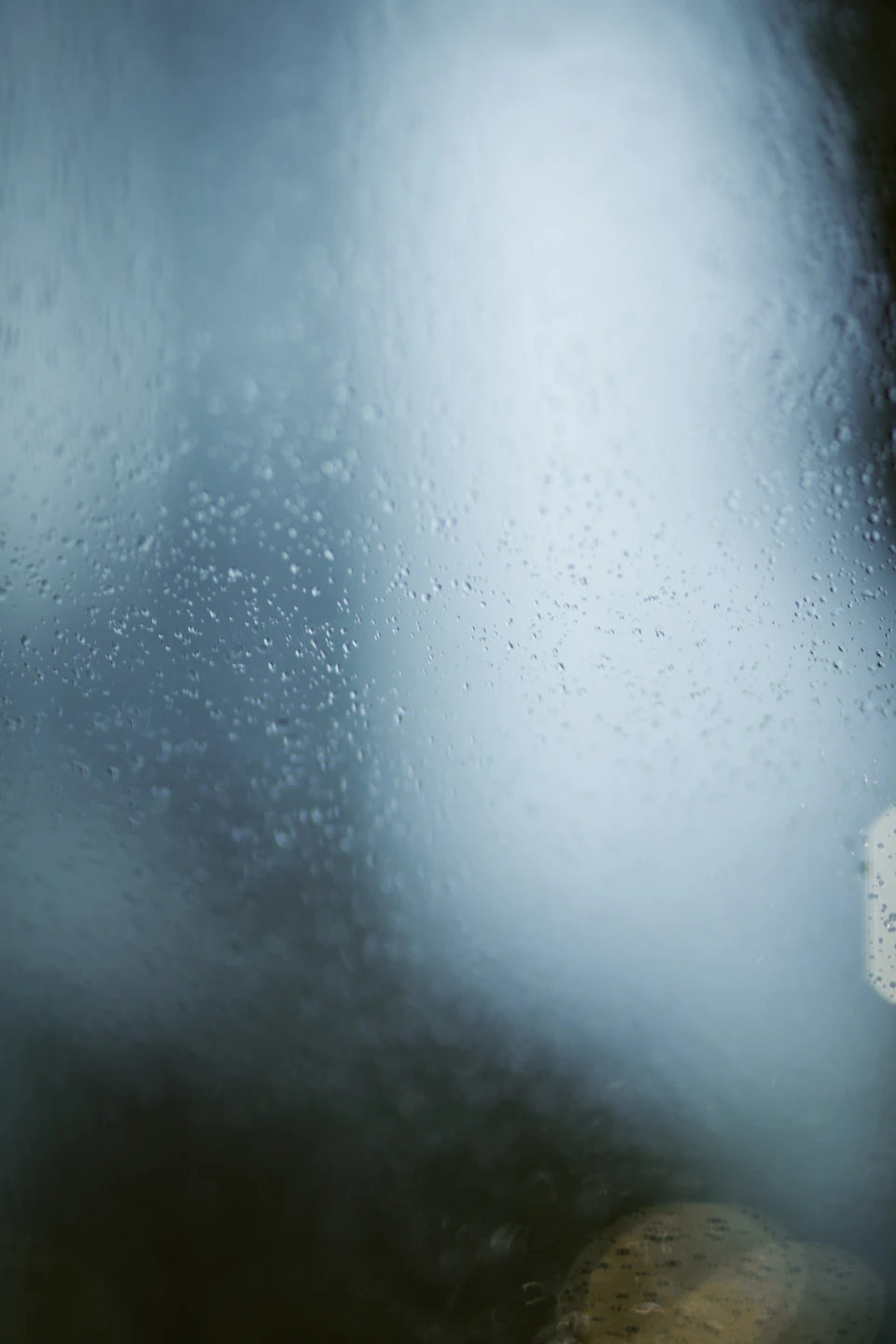 Close-up view of a window with scattered water droplets creating a blurred effect