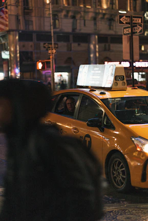 A sleek taxi parked outside a bustling city street at dusk, ready for a one-way trip.