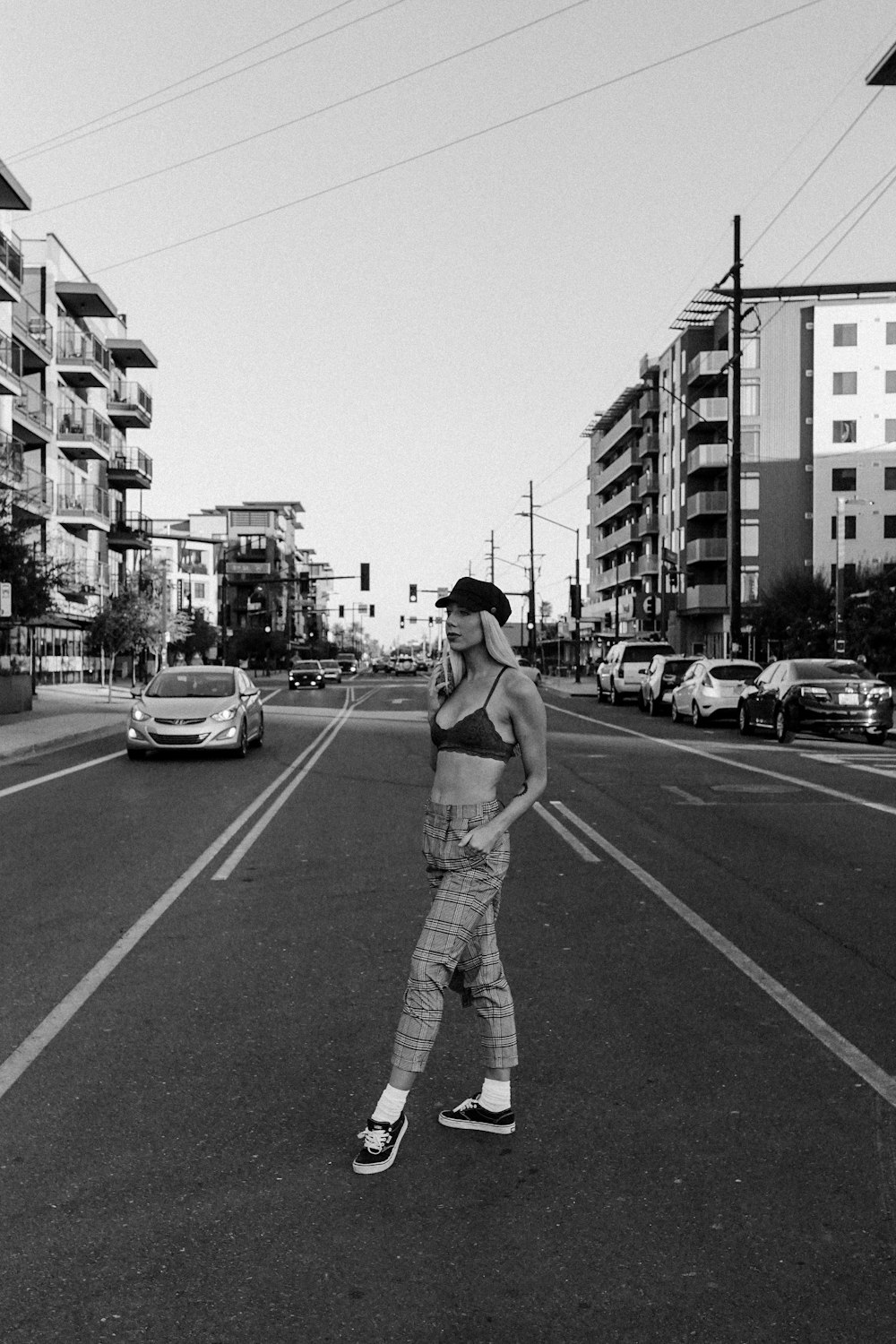 grayscale photography of woman standing on road