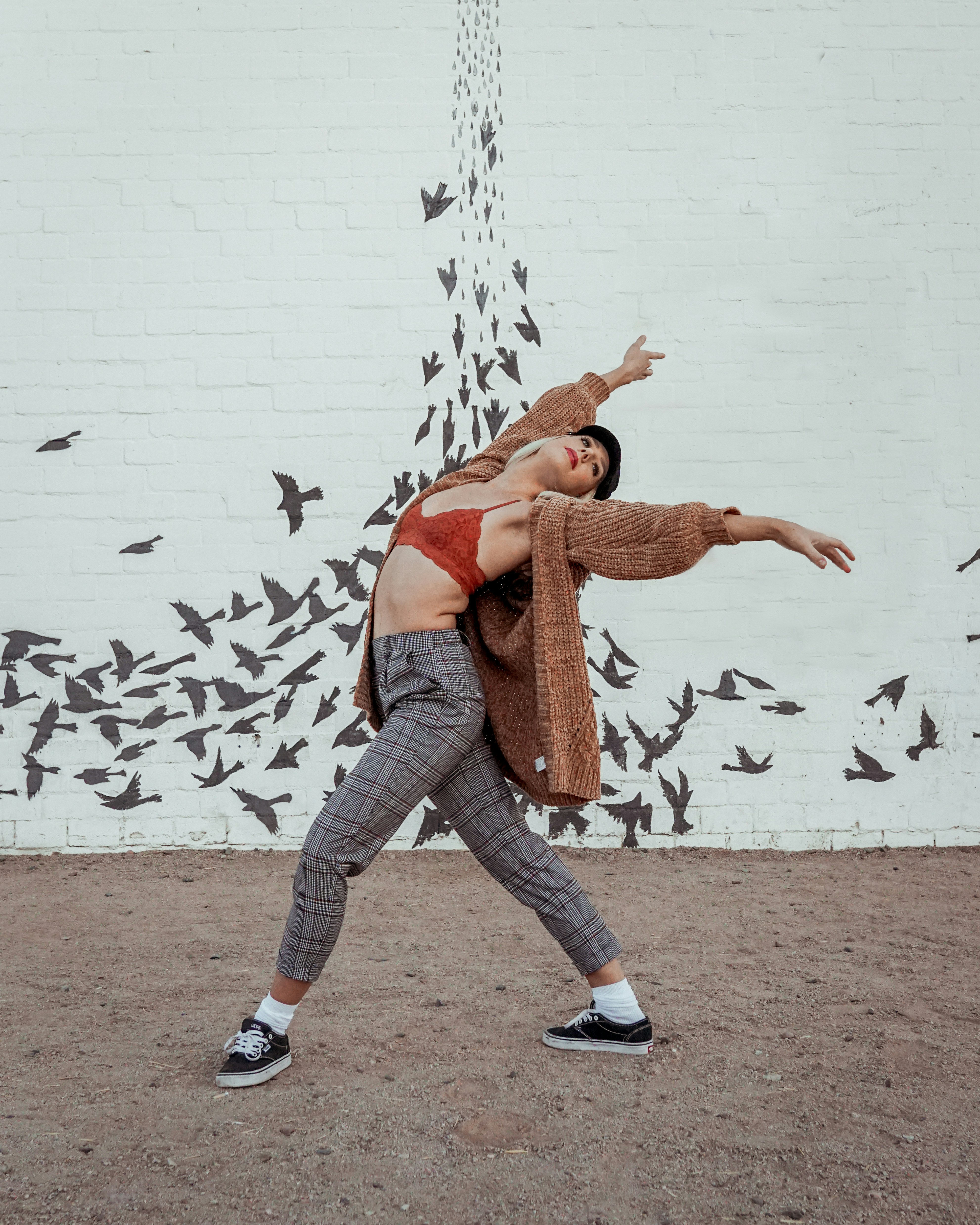 dancing woman wearing brown coat and grey pants