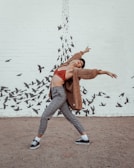 dancing woman wearing brown coat and grey pants