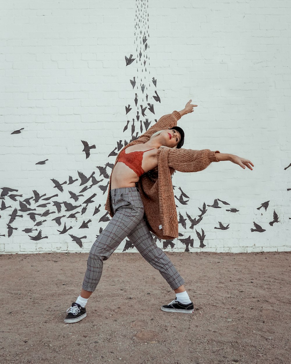 dancing woman wearing brown coat and grey pants