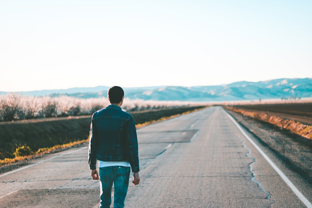 man standing on gray concrete road during daytime