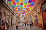 assorted-color umbrella hanged above pathway near houses