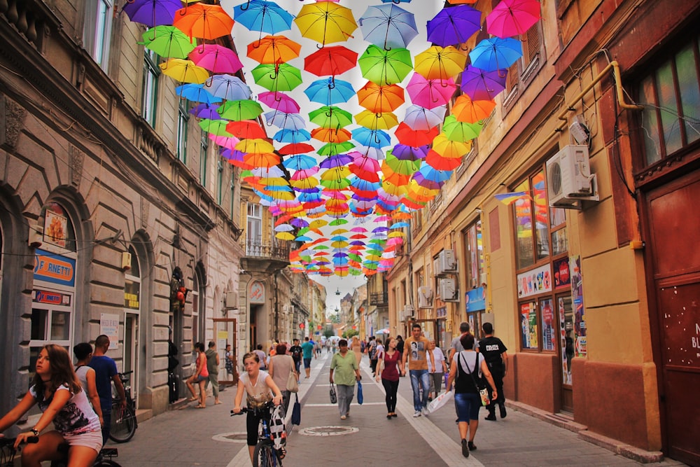 guarda-chuva de cores variadas pendurado acima do caminho perto de casas