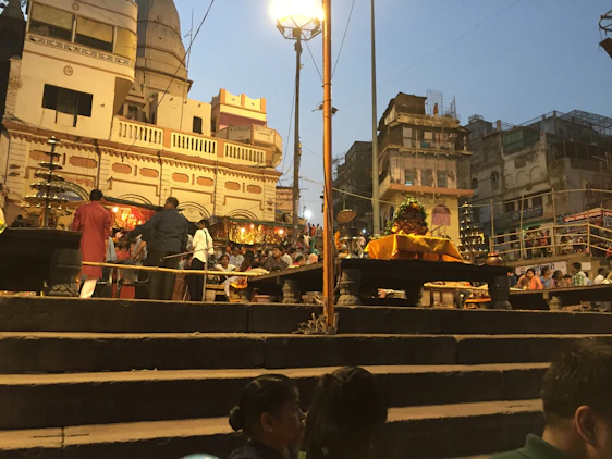 A serene view of the Varanasi Ghats at sunrise, with pilgrims preparing for the Ganga Aarti ceremony.