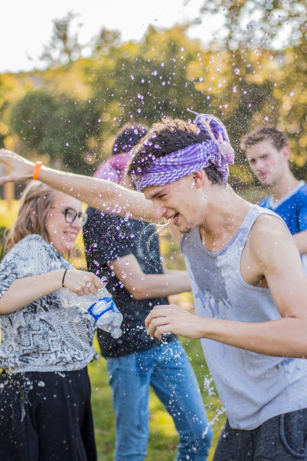 woman holding water bottle near man raising right hand