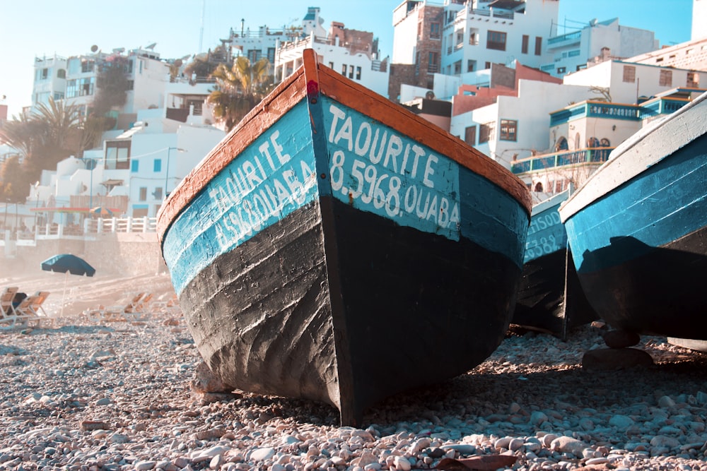 black and teal boat on seashore