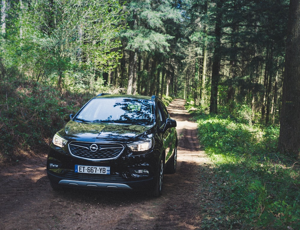black Opel vehicle parked near trees during daytime