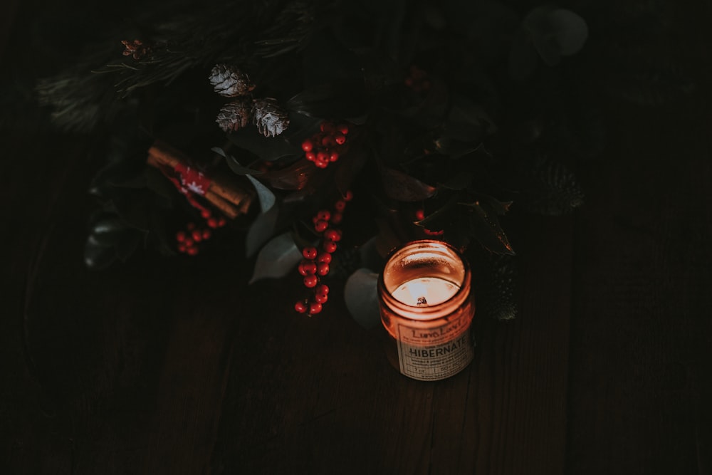 clear glass candle jar beside plants