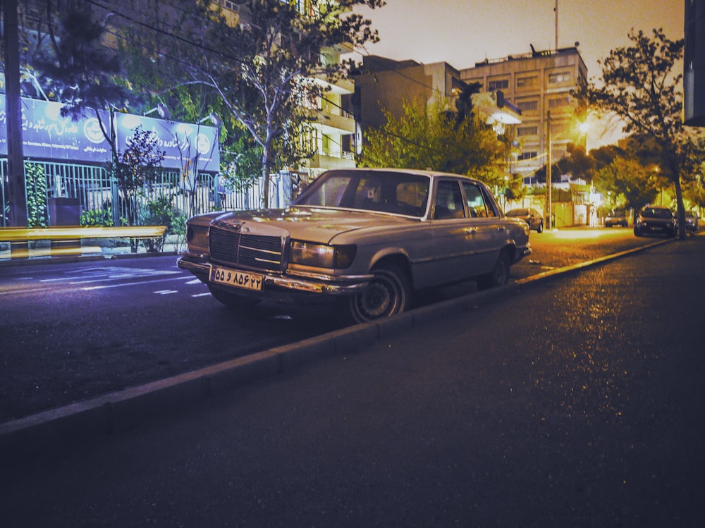 gray sedan parked beside road