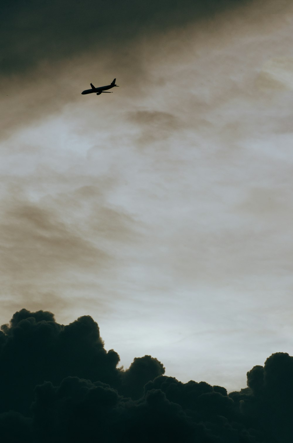 Fliegendes Passagierflugzeug unter bewölktem Himmel