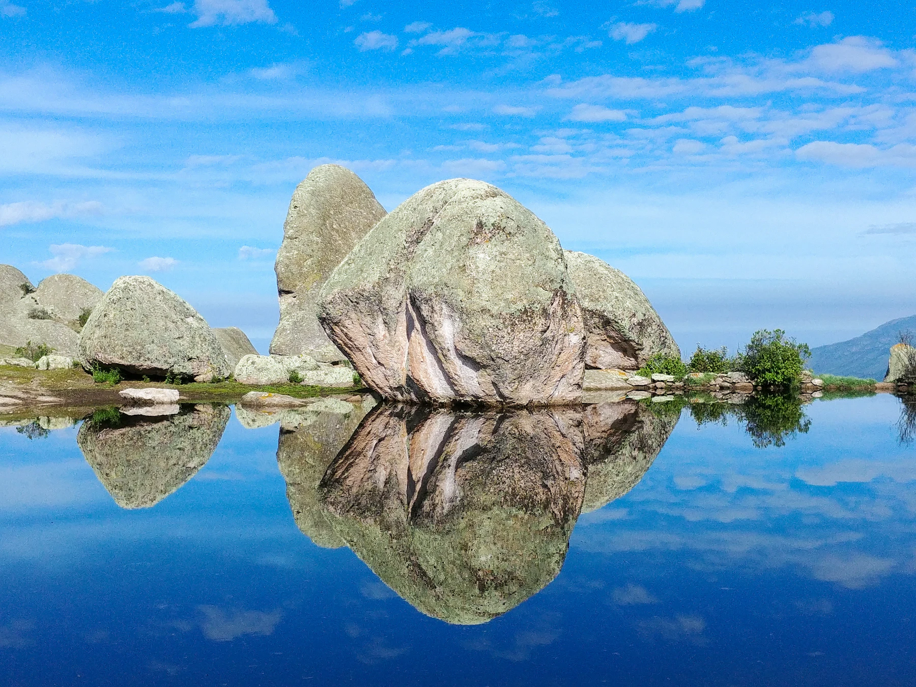 Granite boulders reflected in a still lake