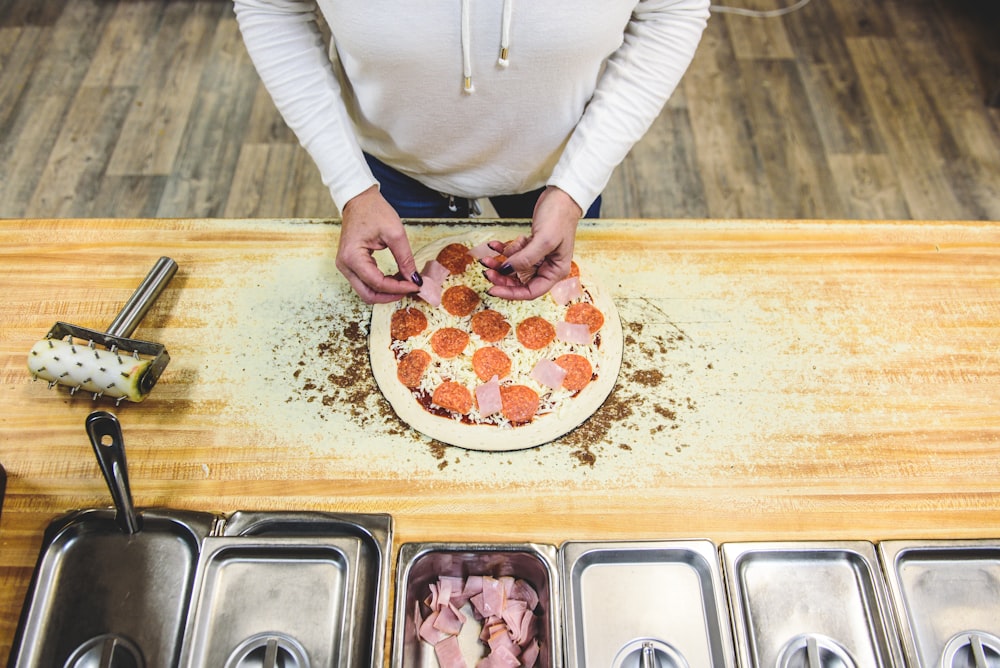 personne en train de cuire une pizza