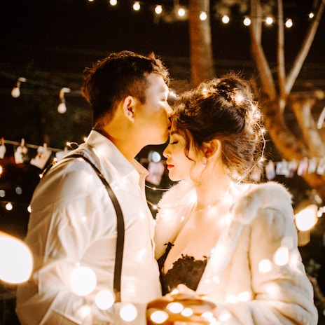 man kissing woman's forehead