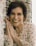 woman in white and orange floral shirt smiling