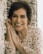 woman in white and orange floral shirt smiling
