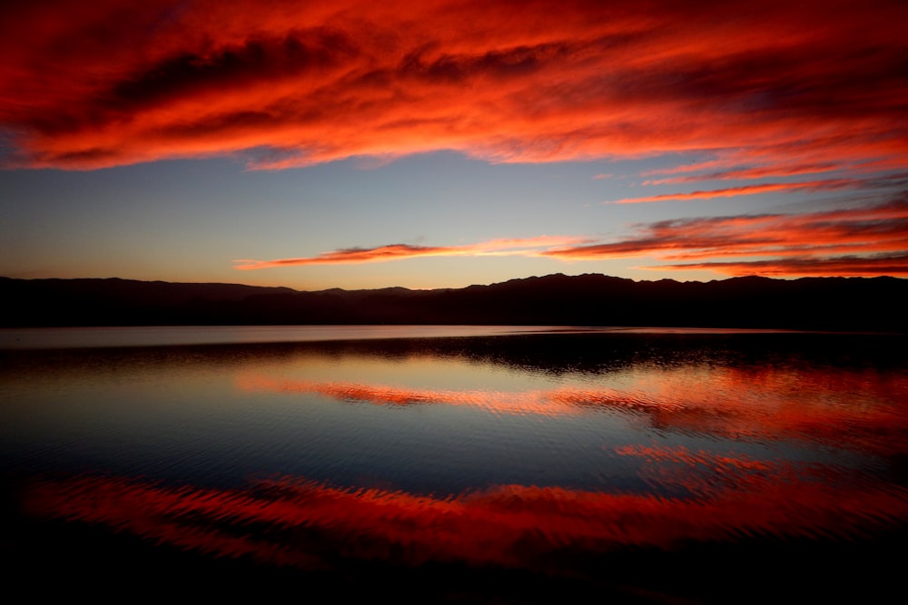 calm body of water under red clouds in timelapse photography