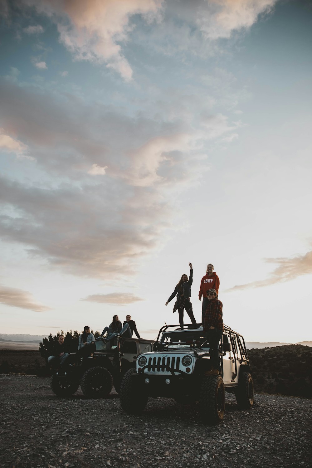 person standing on top of vehicle under white sky