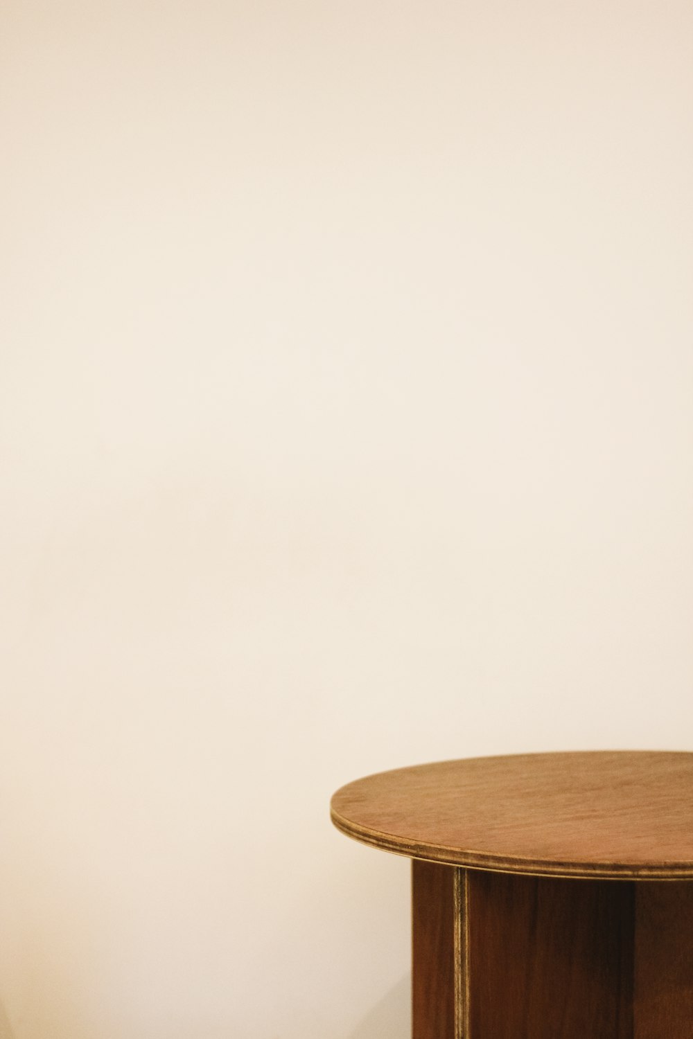 白い壁の横の茶色の木製のエンドテーブル