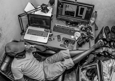 grayscale photography of man sitting on chair