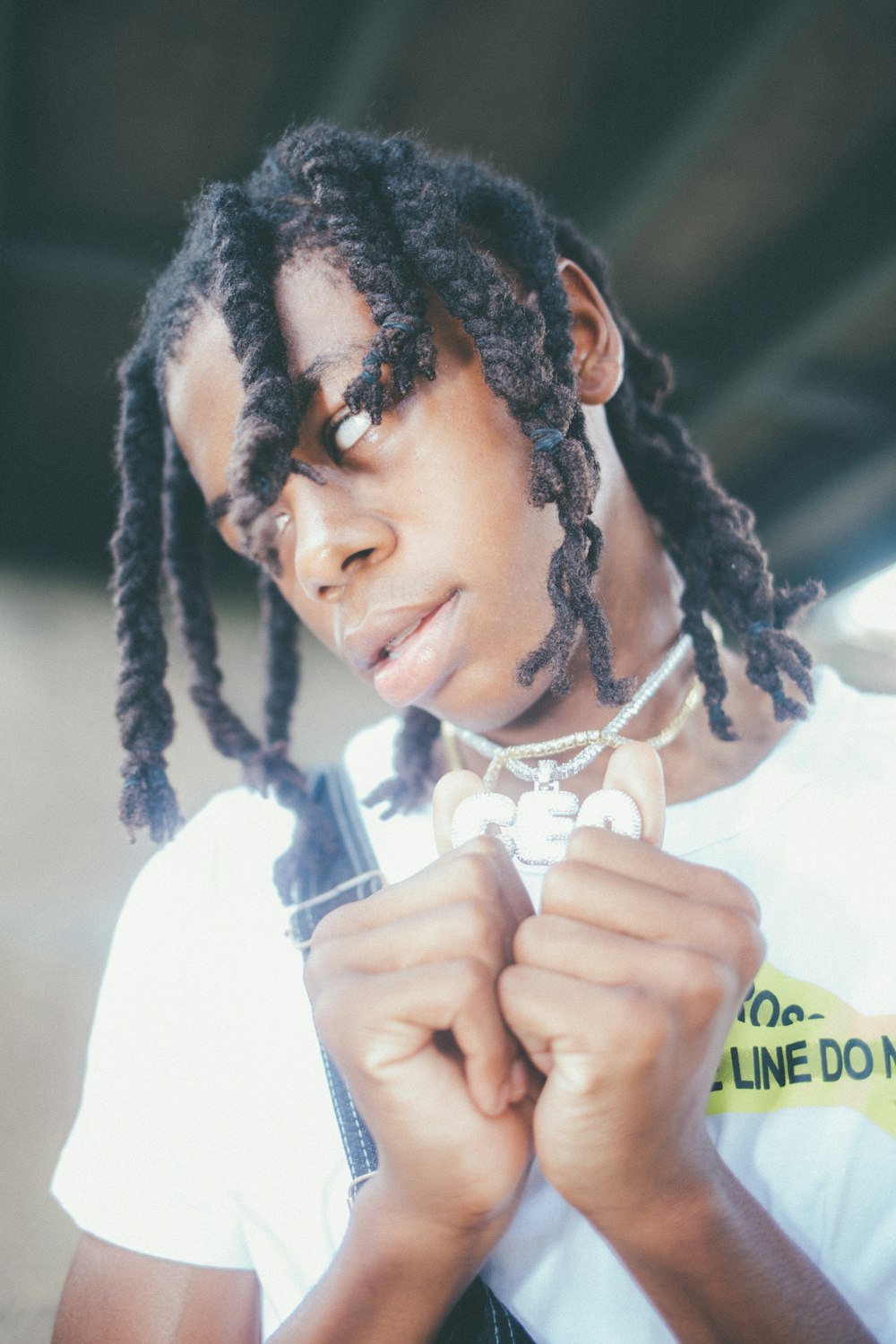 a young man with dreadlocks and a white t - shirt