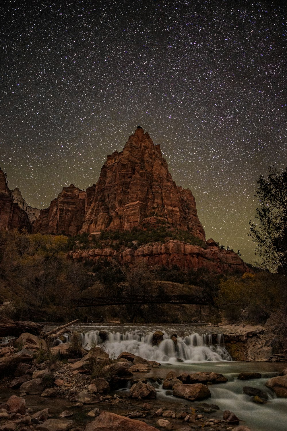 timelapse photography of river overlooking rock mountain at night time