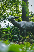 Lawn decorative sculpture of a majestic deer blending into the greenery.
