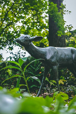 Lawn decorative sculpture of a majestic deer blending into the greenery.