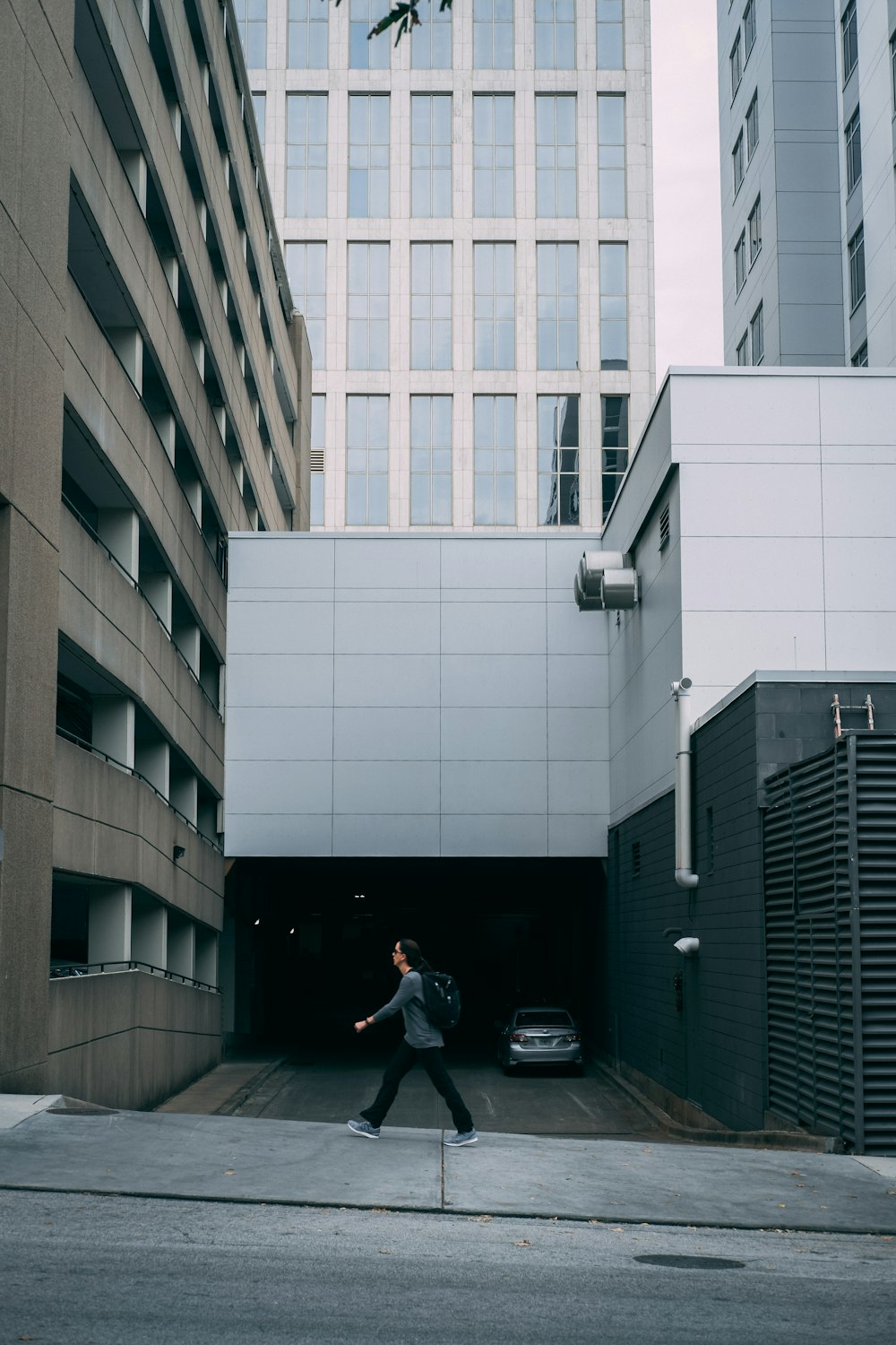 man walks past building driveway