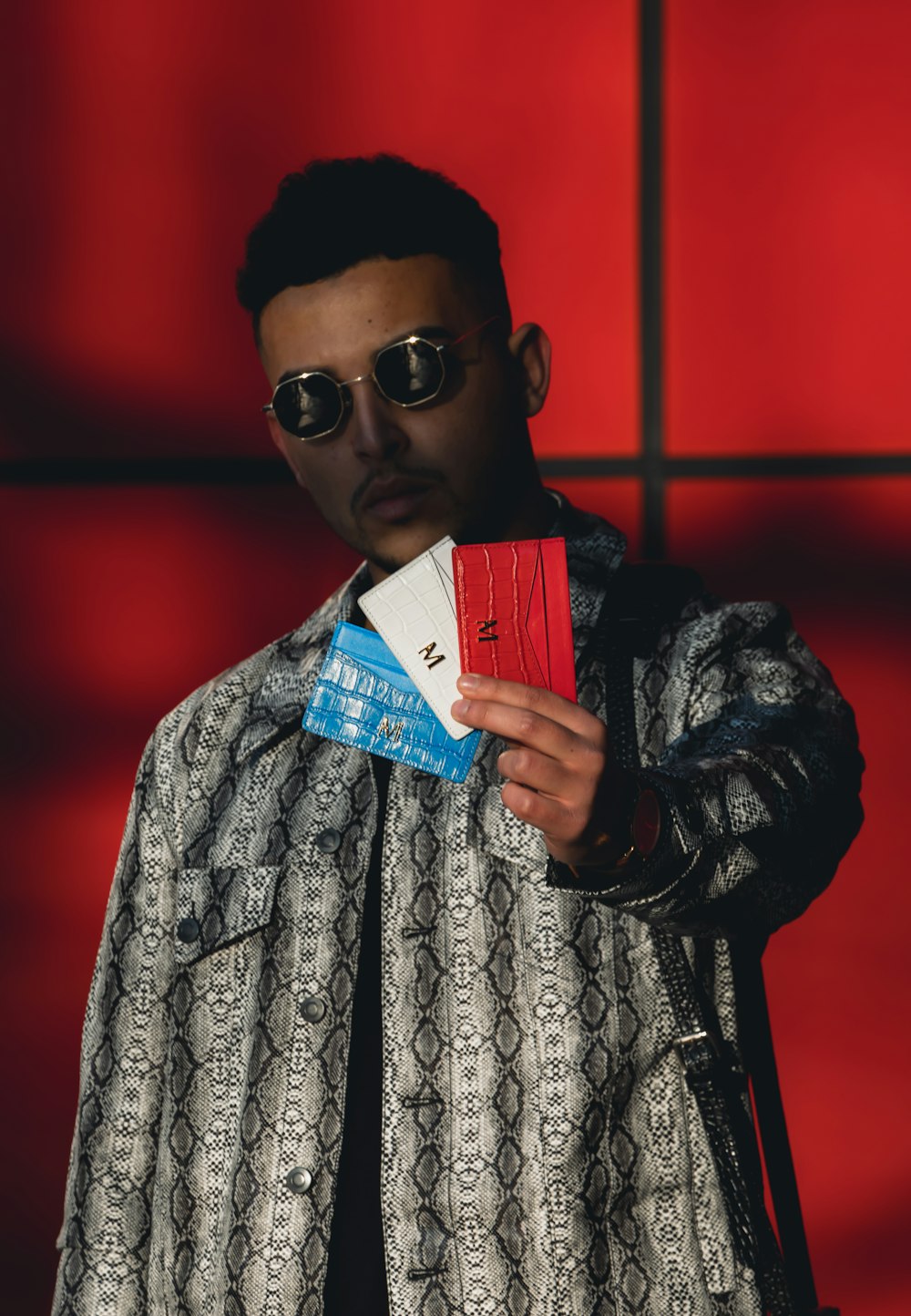 man holding three assorted-color cards