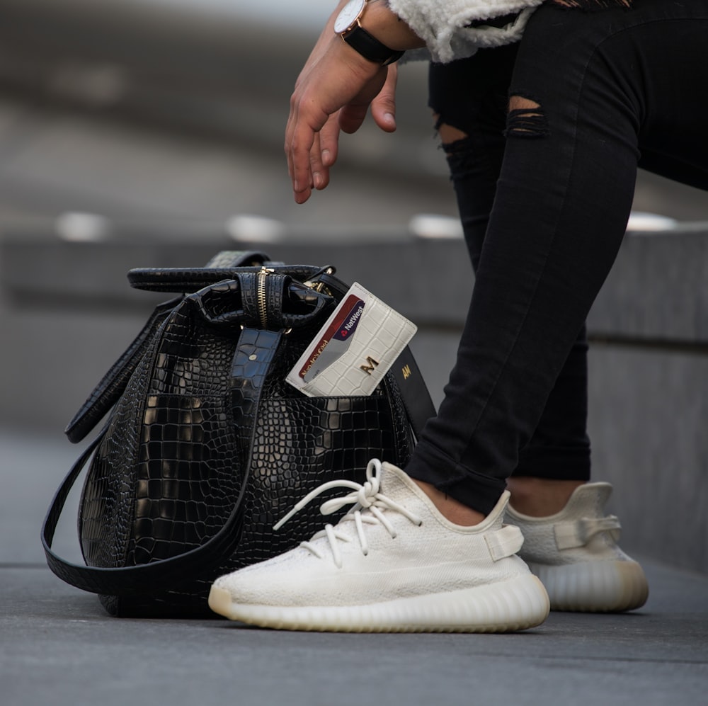 woman in black denim jeans and white Adidas Yeezy Boost sneakers photo –  Free Trainers Image on Unsplash