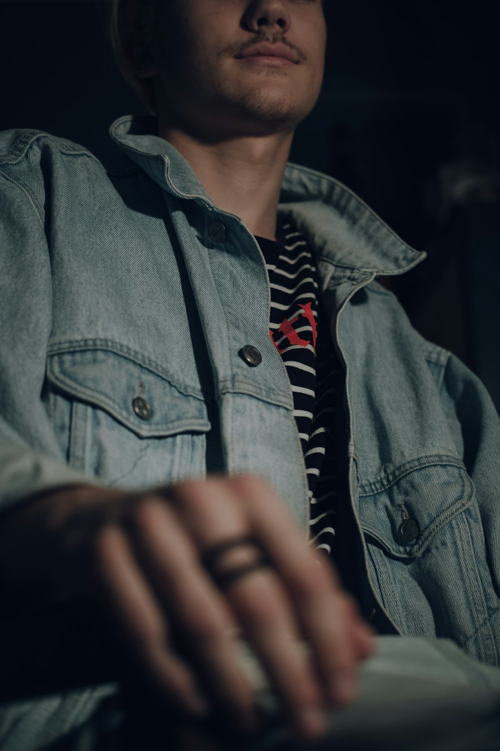 man in blue denim jacket taking close-up selfie