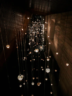 A collection of pendant lights hanging at varying heights over a dining table.