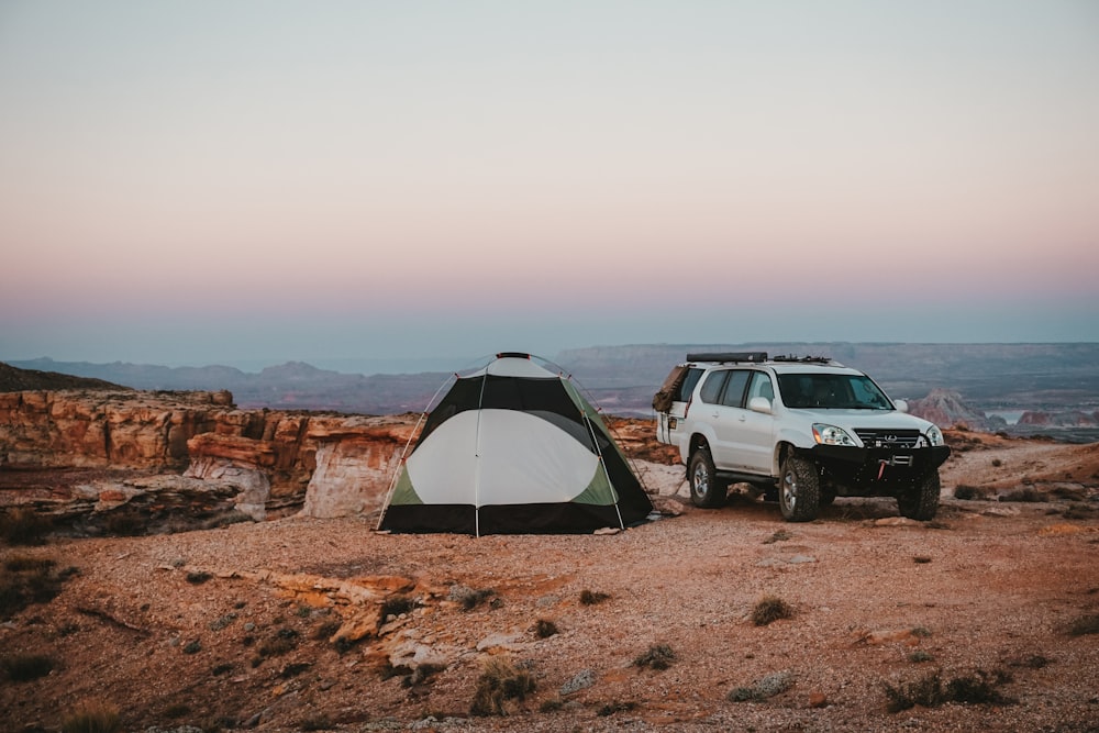 white SUV beside tent