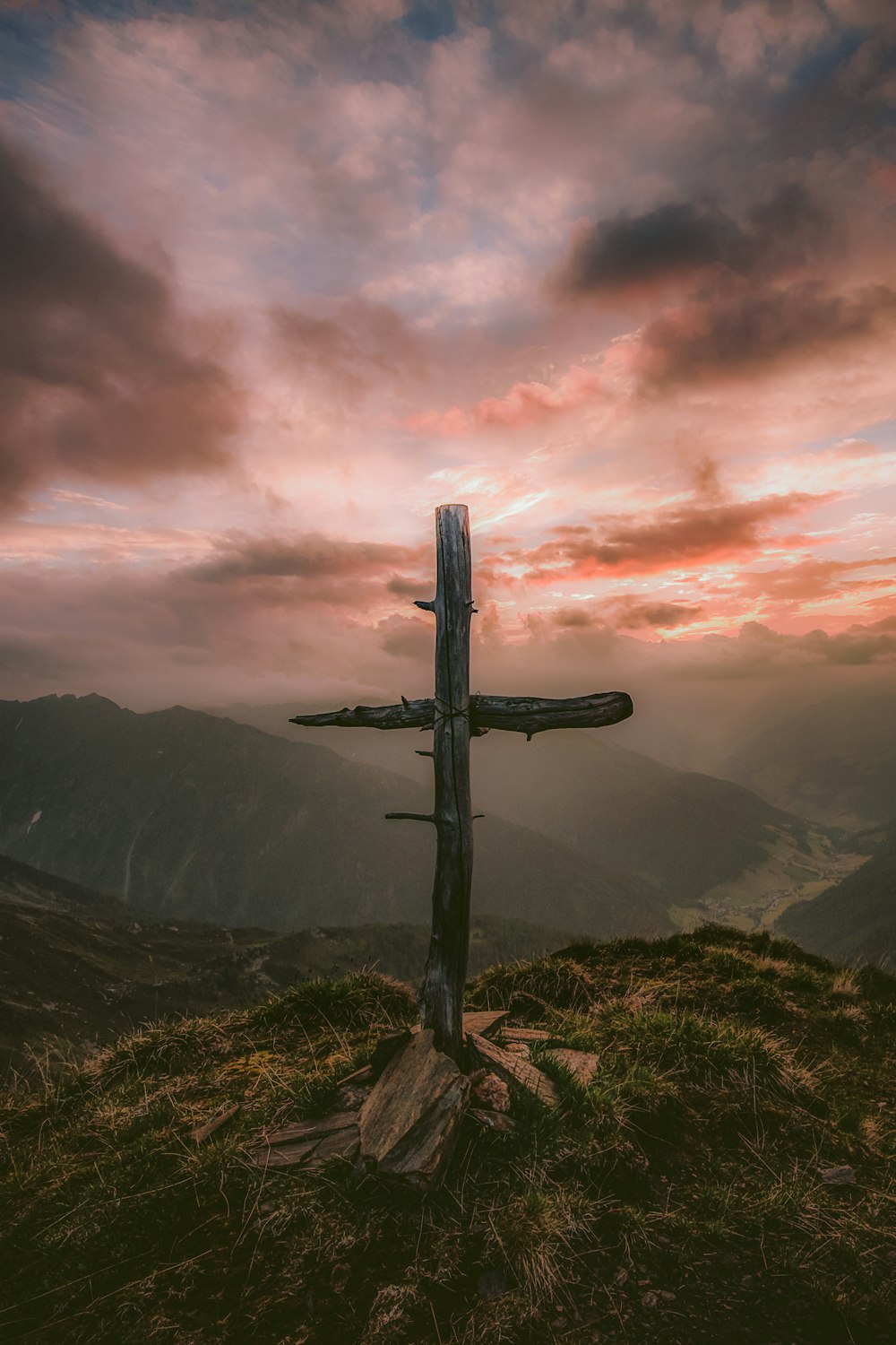 graues Holzkreuz auf Berg