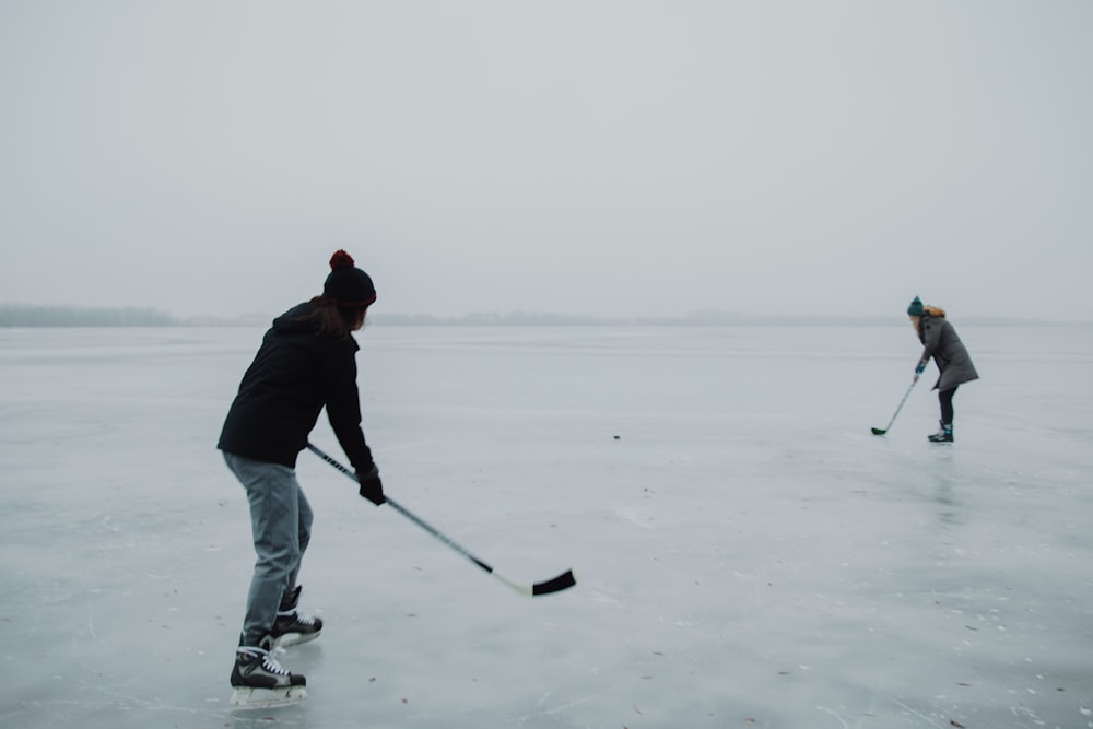 2 people playing hokey on ice