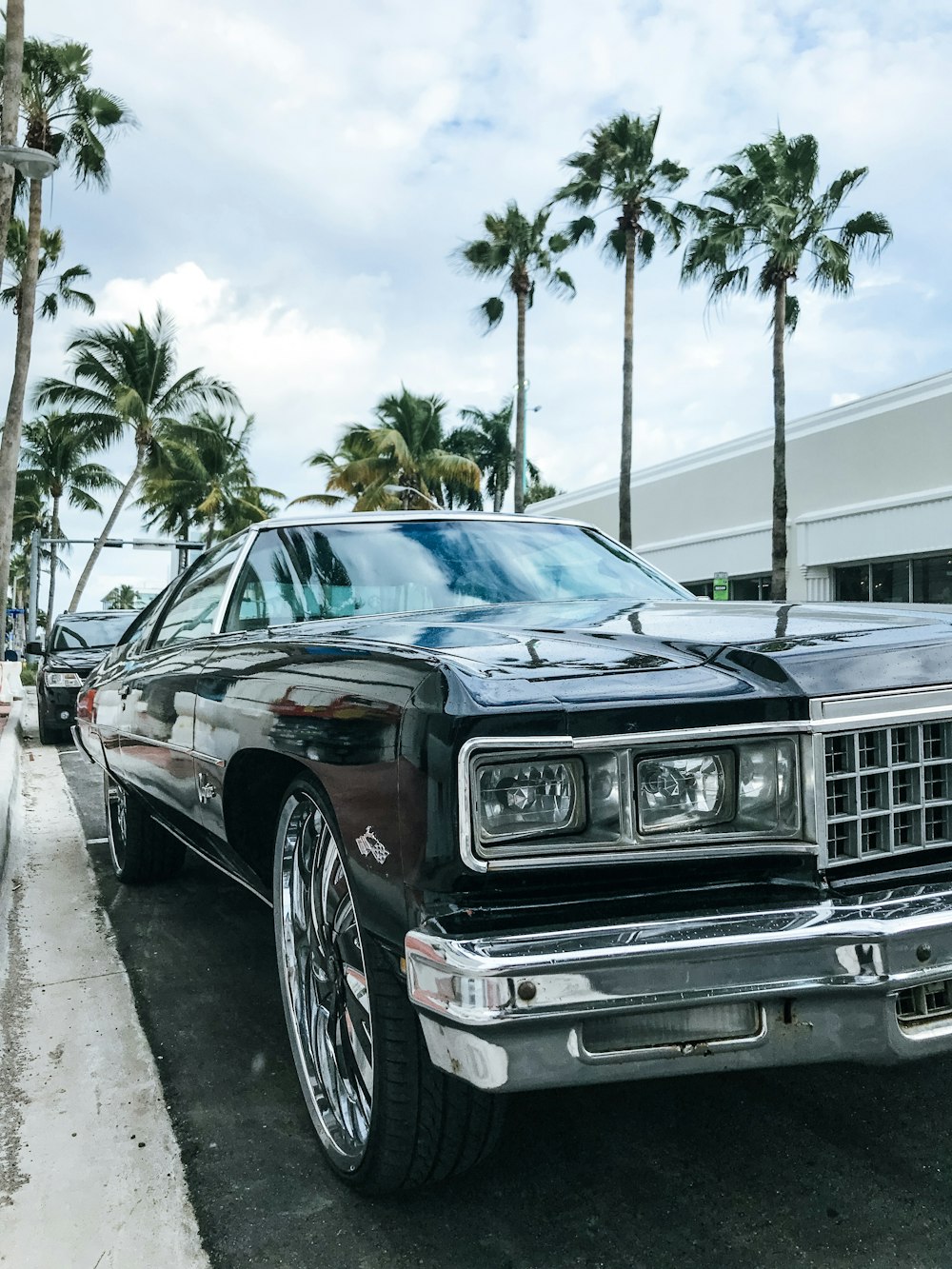 classic black coupe parked on roadside at daytime