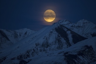 snow coated mountain at night time