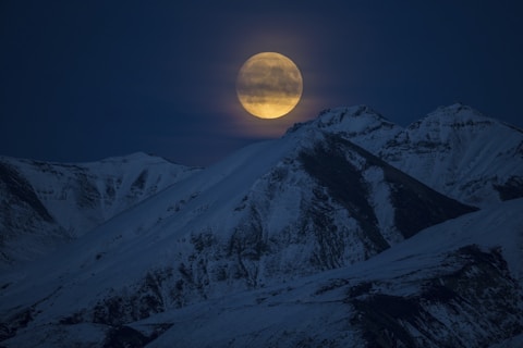 snow coated mountain at night time