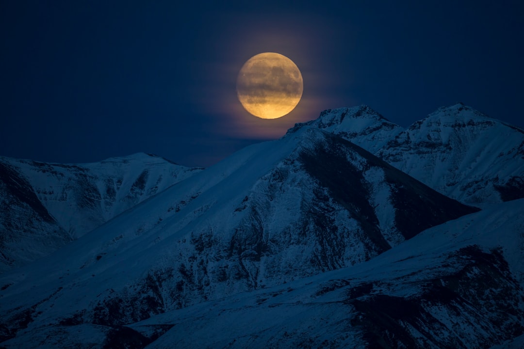 snow coated mountain at night time