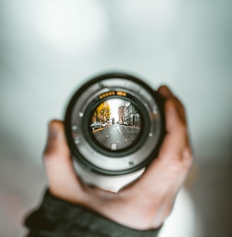 person holding camera lens