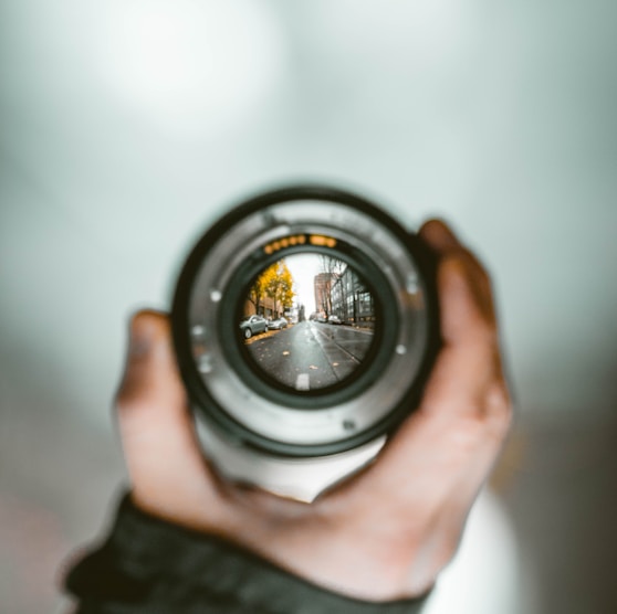 person holding camera lens