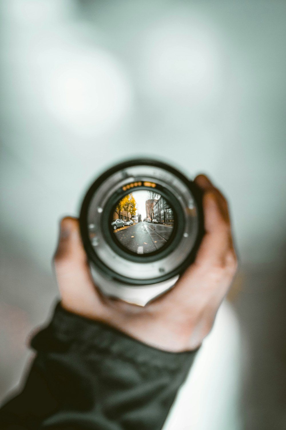 person holding camera lens