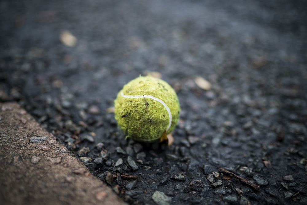 green tennis ball on the pavement