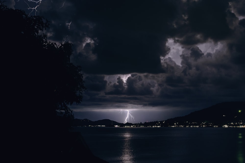 暗い雲の下の町の近くの水域