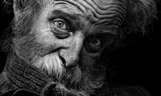 A stark black and white portrait of an elderly man in a bustling Indian market, his eyes reflecting years of stories.