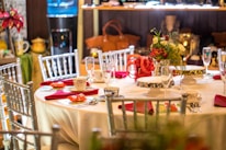 Close-up of pastel red chairs and white tablecloths ready for a festive event.
